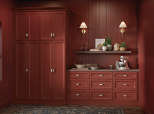 A kitchen with red cabinets, shelves, and wall paneling, adorned with small light fixtures and decorative elements.