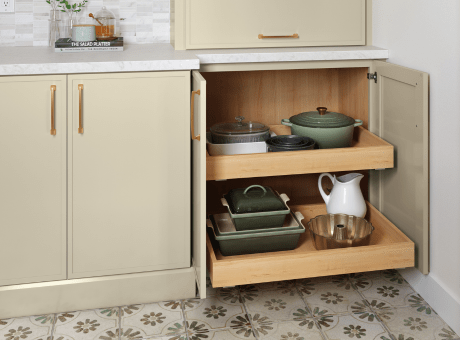 Kitchen cabinet with pull-out shelves and neatly organized cookware.